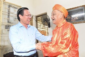 Chairman of the HCMC People’s Committee Phan Van Mai (L) extends 90th birthday greetings to Mr. Nguyen Ngoc Thuan. (Photo: SGGP)