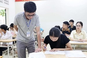 An exam supervisor helps a student verify and cross-check her information. (Photo: VNA)