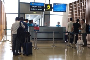 Vietnam Airlines passengers passing through boarding gate (Photo: VNA)