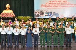 The HCMC People’s Committee of the city presents certificates of merit to military officers soldiers, and volunteers of the H.O.P.E (Have Only Positive Expectation) Center. (Photo: SGGP)