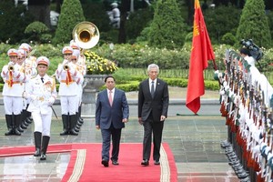 PM Pham Minh Chinh and his Singaporean counterpart Lee Hsien Loong walk on a red carpet at the welcome ceremony in Hanoi on August 28. (Photo: SGGP)