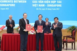 Vietnamese Minister of Planning and Investment Nguyen Chi Dung (R), Minister of Labor, Invalids and Social Affairs Dao Ngoc Dung (C), and Singaporean Minister of Industry and Trade Tan See Leng sign a Memorandum of Understanding (MoU) on the Vietnam-Singapore Innovation Talent Exchange Program. (Photo: SGGP)