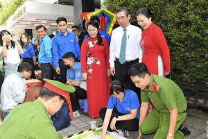 Vice President of the Vietnam Fatherland Front (VFF) Central Committee Truong Thi Ngoc Anh (R), Vice Secretary of the HCMC Party Committee Nguyen Phuoc Loc (2nd, R) enjoy a Vietnamese folk game in the event. (Photo: SGGP)
