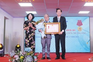 Vice State President Dang Thi Ngoc Thinh (L) and Head of the Internal Affairs Committee of HCMC Party Committee Le Thanh Liem (R) offer the Third-Class Labor Medal to Nguyen Tri Phuong Hospital. (Photo: SGGP)