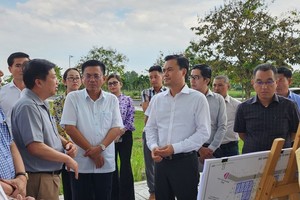 Vice Chairman of the HCMC People’s Committee Bui Xuan Cuong (2nd, R) conducts a field inspection of An Ha resettlement area in Binh Chanh District. (Photo: SGGP)