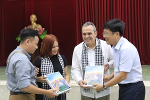 Chairman of the People's Committee of District 8 Tran Thanh Tung (R) presents gifts to Cuban medical experts. (Photo: SGGP)