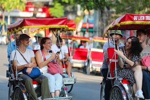 Foreign visitors touring the Hanoi Old Quarter on cyclos (Photo: VNA)