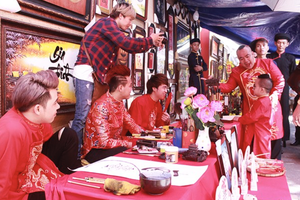 Calligraphers wear traditional costumes and write and sell nice words written in calligraphy to customers at the fetsival. (Photo: SGGP)