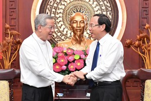 Archbishop of the Archdiocese of HCMC, Joseph Nguyen Nang (L) extends Tet greetings to Secretary of the HCMC Party Committee Nguyen Van Nen. (Photo: SGGP)