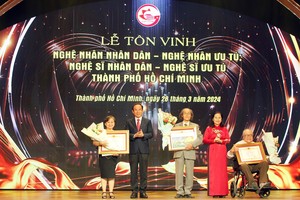 Secretary of the HCMC Party Committee Nguyen Van Nen (2nd, L) and Chairwoman of the People’s Council Nguyen Thi Le (2nd, R) present certidicate of merit to artists. (Photo: SGGP)