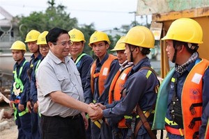 Prime Minister Pham Minh Chinh meets workers at the construction site of a bridge crossing the Huong River. (Photo: VNA)
