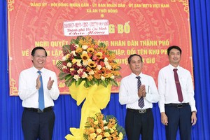 Chairman of the HCMC People's Committee Phan Van Mai (L) congratulates Can Gio District’s An Thoi Dong Commune. (Photo: SGGP)