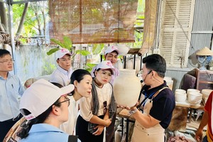 Visitors enjoy pottery making at the Vuon Nha Gom store in Binh Duong province. (Photo: SGGP)