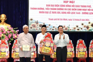 Pham Minh Tuan (first right) , Vice Chairman of the VFF Committee of HCMC, hands over presents to the representative board of the Muslim community in the city. (Photo: SGGP)