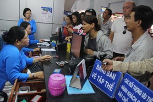 Passengers buy train tickets at a station. (Photo: SGGP)