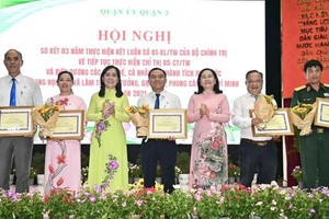Chairwoman of the HCMC People’s Council Nguyen Thi Le (3rd, R) and Secretary of the Party Committee of District 3 Nguyen Thanh Xuan (3rd, L) present certificates of merit to typical individuals and collectives. (Photo: SGGP)