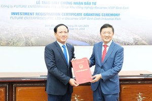 Chairman of the Binh Dinh Province People's Committee, Pham Anh Tuan (L) grants the Investment Registration Certificate to Future Enterprises Pte. Ltd. (Photo: SGGP)