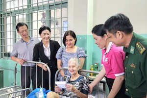 Delegates present gifts to old people in the Thanh Loc Care Center for Paralyzed People. (Photo: SGGP)