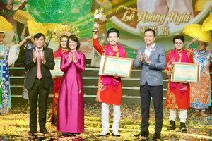 Chairwoman of the HCMC People’s Committee Tran Thi Dieu Thuy (2nd, L), and deputy Head of the Propaganda and Education Board of the HCMC Party Committee Tang Huu Phong (L) present the Golden Bell Award to Le Hoang Nghi. (Photo: SGGP)