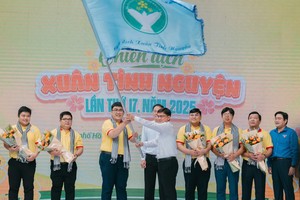 Head of the Ho Chi Minh City Party Committee's Mass Mobilization Commission Nguyen Manh Cuong hands over the flag to volunteers on the launching ceremony of the 17th Spring Volunteer Campaign. (Photo: SGGP)