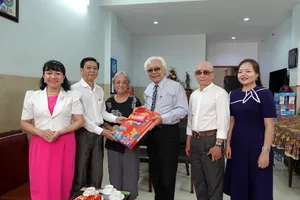 The delegation of Ho Chi Minh City's officials offers a Tet gift to musician Tran Xuan Tien (3rd, R). (Photo: SGGP)