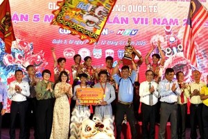 Vice Secretary of the Ho Chi Minh City Party Committee cum Chairman of the Vietnam Fatherland Front Committee of the city Nguyen Phuoc Loc and Vice Chairwoman of the municipal People’s Committee Tran Thi Dieu Thuy present the first rize to the Mieu Bay Ba kylin, lion, and dragon dance troupe of An Giang province. (Photo: SGGP)