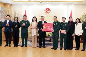 Vice Secretary of the Party Committee cum Chairman of the Vietnam Fatherland Front Committee of Ho Chi Minh City Nguyen Phuoc Loc (6th, L) offers a Tet gift to the Party Committee of the Vietnam Border Guard High Command. (Photo: SGGP)