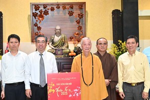 The delegation offers a Tet gift to Most Venerable Thich Tri Quang. (Photo: SGGP)