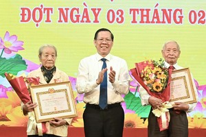 Chairman of the Ho Chi Minh City People’s Committee Phan Van Mai presents Party membership badges to Party members in District 1. (Photo: SGGP)