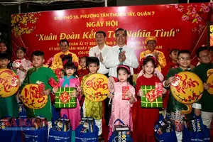 Vice Secretary of the Ho Chi Minh City Party Committee Nguyen Phuoc Loc offers lucky money to children. (Photo: SGGP)
