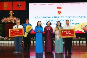Chairwoman of the Ho Chi Minh City People’s Council Nguyen Thi Le (3rd, L) and former Head of the Propaganda and Education Board of the HCMC Party Committee Than Thi Thu (3rd, R) present 50-year Party membership badges to veteran Party members. (Photo: SGGP)