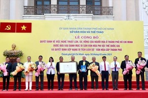 Head of the Propaganda and Mass Mobilization Commission Nguyen Manh Cuong (5th, R) and Vice Chairwoman of the People’s Committee of the city Tran Thi Dieu Thuy (6th, L) hand over certificate to recognize the art of the Kylin-Lion-Dragon dance of the city as a National Intangible Cultural Heritage. (Photo: SGGP)