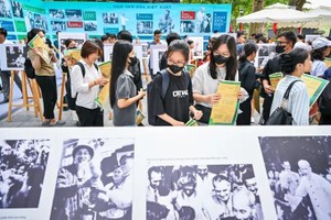 Visitors visit a photo exhibition titled “The Light of His Name”held by Nhan Dan (The People)’s Newspaper. (Photo: SGGP)