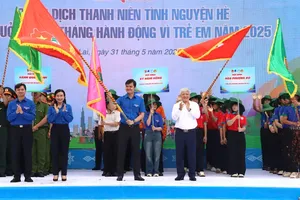 Chairman of the Central Committee of the Vietnam Fatherland Front Do Van Chien (R) hands over a flag to the Ho Chi Minh Communist Youth Union Central Committee to kick off the 2025 Summer Youth Volunteer Campaign. (Photo: SGGP)