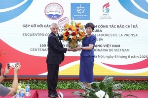 A representative of Prensa Latina News Agency in Vietnam presents flowers to General Director of the Vietnam News Agency Vu Viet Trang to congratulate the agency on the occasion of the 100th anniversary of Vietnamese Revolutionary Press Day. (Photo: VNA)