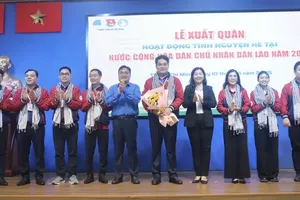 Deputy Head of the Propaganda and Mass Mobilization Commission of the the Ho Chi Minh City Party Committee, Nguyen Thi Bach Mai (4th, R) and Secretary of the Ho Chi Minh City Youth Union cum Chairman of the Vietnam Youth Federation in the city, Ngo Minh Hai (5th, L) offer flowers to volunteers. (Photo: SGGP)