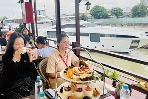 Tourists enjoy tea on a floating restaurant on the Sai Gon River.