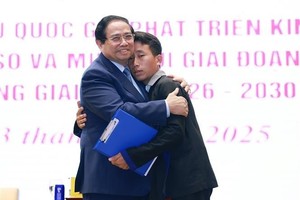 Prime Minister Pham Minh Chinh and Mua A Thi, head of Hang Pu Xi hamlet in Xa Dung commune of Dien Bien province, who saves 90 villagers from flash floods and landslides in the early morning of August 1. (Photo: VNA)