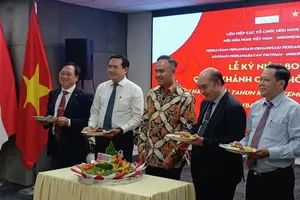 Acting Indonesian Consul General in Ho Chi Minh City, Adiguna Wijaya (center), joins delegates in sharing traditional Indonesian dishes during a gathering. (Photo: SGGP)