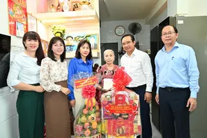 Chairman of the Ho Chi Minh City People’s Committee Nguyen Van Duoc and delegates offer a gift to Vietnamese Heroic Mother Le Thi Hanh. (Photo: SGGP)