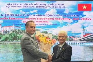 Mr. Bui Quang Hai (R) offers flowers to Chargé d'Affaires of the Slovak Republic in Vietnam, Marian Veress on the Slovakia National Day. (Photo: SGGP)