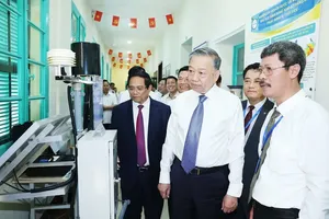 Party General Secretary To Lam (centre) and PM Pham Minh Chinh (left) are briefed on the use of nuclear energy for peaceful purposes. (Photo: VNA)