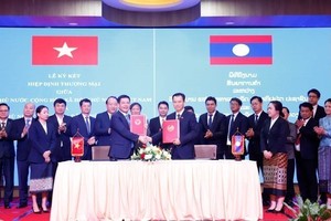 Minister of Industry and Trade Nguyen Hong Dien and his Lao counterpart Malaithong Kommasith sign the Vietnam - Laos Trade Agreement on April 8, 2024. (Photo: VNA)