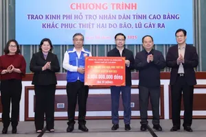 Vice Secretary of the Ho Chi Minh City Party Committee Nguyen Phuoc Loc (3rd, L) presents aid to help residents of Cao Bang Province recover from storm and flood damage. (Photo: SGGP)