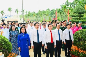 The delegation pays tribute with flowers and incense at the Nga Ba Giong National Historical Site. (Photo: SGGP)