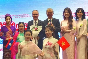 President of the Vietnam-Laos Friendship Association's HCMC chapter Ngo Minh Chau presents flowers to Mr. Phonesy Bounmixay, Consul General of Laos to HCMC. (Photo: SGGP)