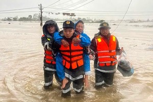 Police officers assist elderly residents in evacuating from deeply flooded areas in Dak Lak province. (Illustrative photo: VNA)