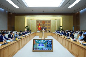 Prime Minister Pham Minh Chinh (centre) chairs a hybrid meeting meeting with ministries, central agencies and local authorities on December 17 to review the implementation of the “Quang Trung Campaign” to rebuild and repair homes that are severely damaged by recent storms and floods. (Photo: VNA)
