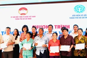 The Vietnam Fatherland Front Committee in Ho Chi Minh City and the city's Social Insurance Agency present health insurance cards to underprivileged residents. (Photo: SGGP)