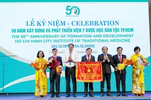 Standing Vice Chairman of the Ho Chi Minh City Vietnam Fatherland Front Committee, Nguyen Thanh Trung presents the Emulation Flag to the Ho Chi Minh City Institute of Traditional Medicine. (Photo: SGGP)